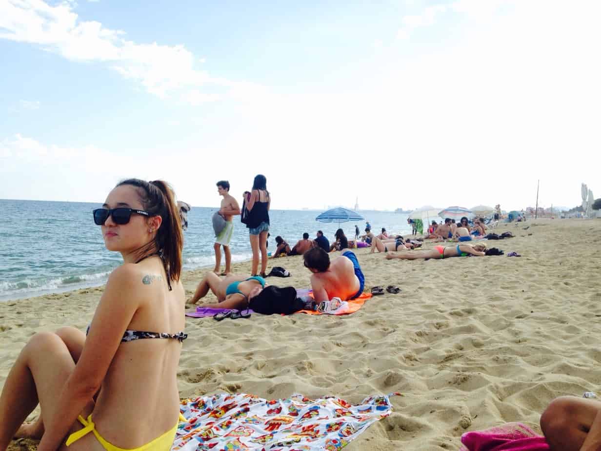 People relaxing on the sand near the water.