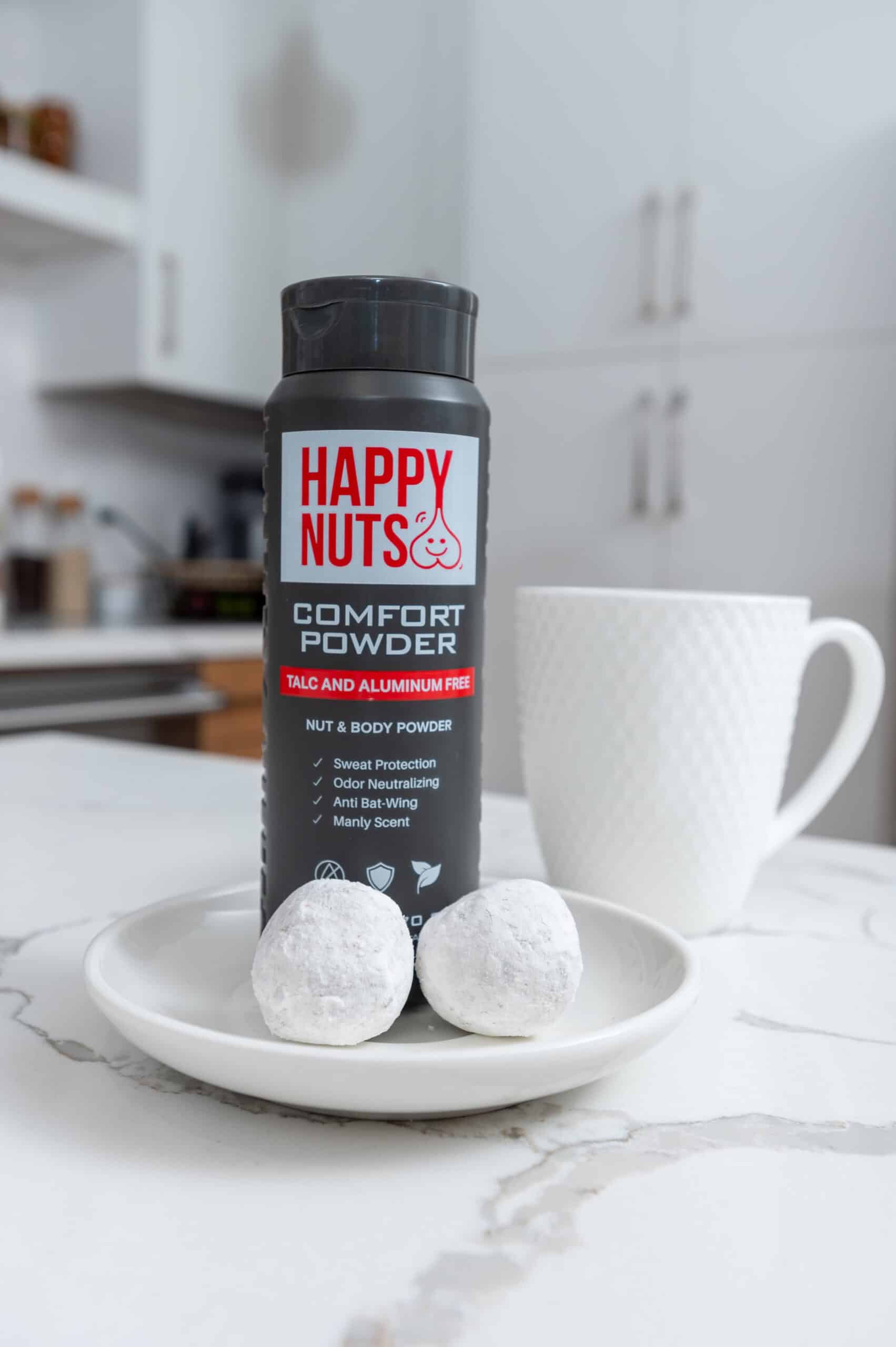 a black can of powder on a plate with white balls on it