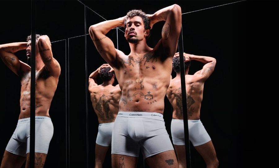 Bad Bunny photographed by Mario Sorrenti for the Calvin Klein Icon Cotton Stretch spring 2025 underwear campaign against a mirrored backdrop